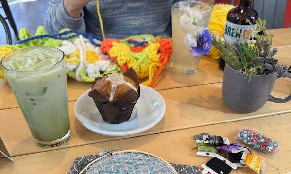 Cafe meetup with match tea and a muffin working on needle point